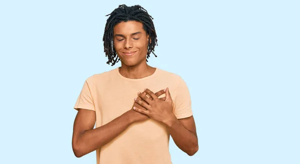 目を閉じて胸に手で笑顔でカジュアルな服を着ている若いアフリカ系アメリカ人男性と顔に感謝のジェスチャー 健康の概念 — ストック写真