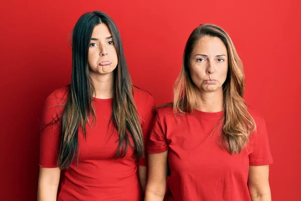 Família Hispânica Mãe Filha Vestindo Roupas Casuais Sobre Fundo Vermelho — Fotografia de Stock