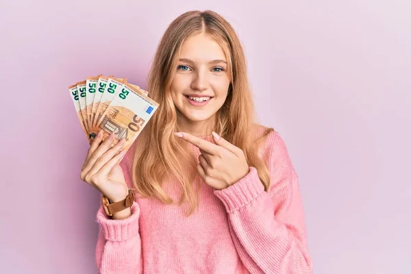 Krásná Mladá Běloška Drží Svazek Eurobankovek Úsměvem Ukazující Rukou Prstem — Stock fotografie