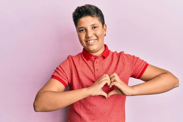 少年惊慌失措的男孩穿着休闲装 带着爱的笑容用手做着心形符号 浪漫的概念 — 图库照片