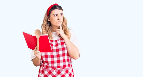 Jovem Mulher Caucasiana Vestindo Avental Segurando Livro Receitas Colher Rosto — Fotografia de Stock