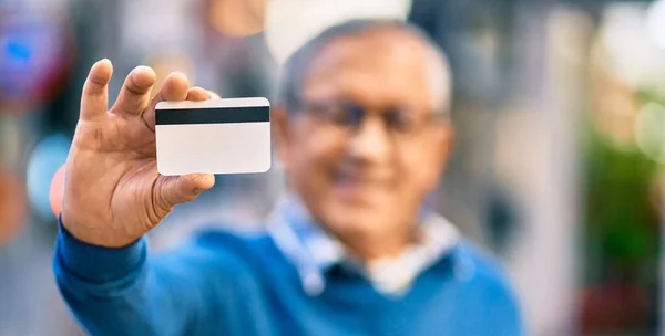 Hombre Pelo Gris Mayor Sonriendo Feliz Sosteniendo Tarjeta Crédito Ciudad —  Fotos de Stock