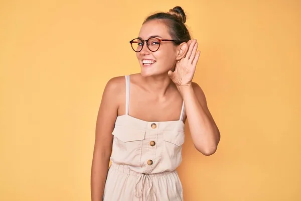 噂やゴシップに耳を傾ける耳の上に手で笑みを浮かべて夏のドレスを着て美しい白人女性 聴覚障害の概念 — ストック写真