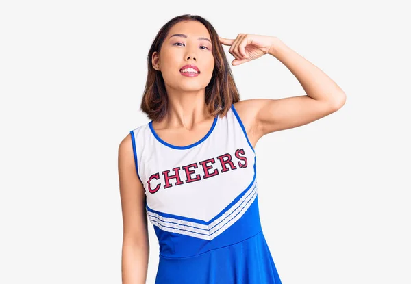 Young Beautiful Chinese Girl Wearing Cheerleader Uniform Smiling Pointing Head — Stock Photo, Image