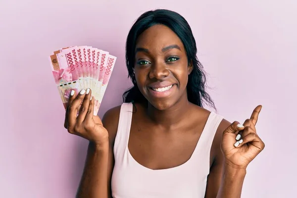 Mladá Africká Americká Žena Držící Indonéské Rupiah Bankovky Úsměvem Šťastně — Stock fotografie