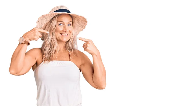 中年适合金发碧眼的女人戴着夏帽 笑容满面 用手指 牙齿和嘴指尖 牙齿健康概念 — 图库照片