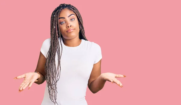 カジュアルな服を着た若いアフリカ系アメリカ人女性は 腕や手を上げて混乱した表情をしています 疑わしい概念 — ストック写真