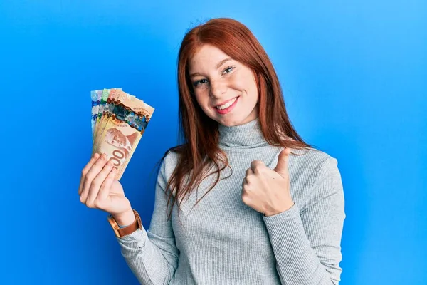 Menina Cabeça Vermelha Jovem Segurando Dólares Canadenses Sorrindo Feliz Positivo — Fotografia de Stock