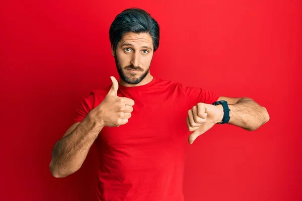 Fiatal Spanyol Férfi Alkalmi Piros Pólóban Hüvelykujjal Fel Nézeteltérés Egyetértés — Stock Fotó