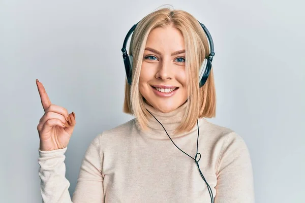 Jovem Loira Ouvindo Música Usando Fones Ouvido Sorrindo Feliz Apontando — Fotografia de Stock