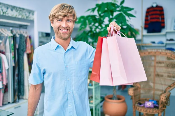 ショッピングセンターの小売店で幸せなショッピングを笑顔でハンサムな白人男性 — ストック写真