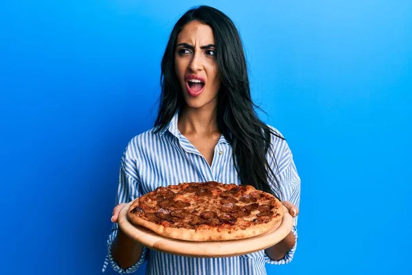 Hermosa Mujer Hispana Sosteniendo Sabrosa Pizza Pepperoni Enojada Loca Gritando — Foto de Stock