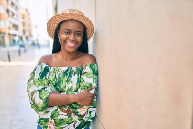 Genç Afrikalı Amerikalı turist kadın tatilde, şehirde mutlu bir şekilde gülümsüyor..