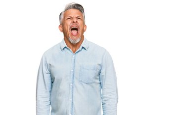 Orta yaşlı, gri saçlı, günlük kıyafetler giyen kızgın ve kızgın çığlık atan sinirli, öfkeyle bağıran bir adam. öfke ve agresif konsept. 