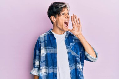 Latin asıllı genç adam günlük kıyafetler giyip el ele tutuşarak bağırıyor ve çığlık atıyordu. iletişim konsepti. 