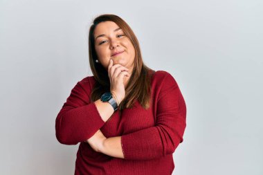 Güzel esmer, iri yarı, sıradan kıyafetler giyen, gülümseyen kolları çapraz ve çenesi açık kameraya bakan bir kadın. Olumlu düşünmek. 