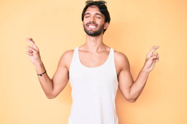 Yaz bakışı ve güneş gözlüğü takan yakışıklı İspanyol adam umut ve gözler kapalı gülümseyerek el sallıyor. Şans ve batıl inançlar. 