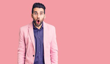 Sakallı, zarif ceketli, ağzı açık, korkmuş ve şaşırmış genç, yakışıklı bir adam. 