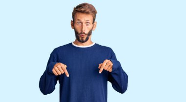 Sakallı, sıradan kazaklı yakışıklı bir adam parmaklarını göstererek reklamını yapıyor, şaşırmış yüzünü ve ağzını açıyor. 