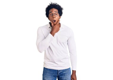 Afro saçlı, sıradan giyinmiş ve gözlüklü yakışıklı Afro-Amerikalı adam. İnançsızlıktan, şaşkınlıktan ve elleri çenesinde olan şaşkınlıktan büyülenmiş görünüyor. 