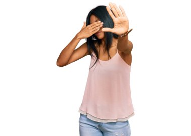 Genç Afro-Amerikalı kadın, günlük kıyafetler ve gözlük takıyor, gözleri ellerle örtüyor ve üzgün ve korku ifadeleriyle jestleri durduruyor. utangaç ve olumsuz kavram. 