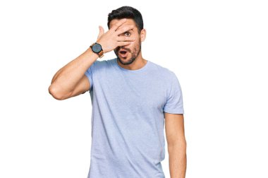 Gündelik kıyafetler giyen genç İspanyol adam şok içinde yüzünü ve gözlerini kapayarak utanmış ifadesiyle parmaklarından bakıyor.. 