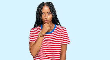 Gündelik giysiler giyen güzel İspanyol kadın elleri çenesinde, inanamama, şaşkınlık ve şaşkınlık dolu bir ifade takınıyor. 