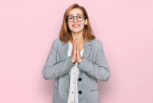 ビジネススタイルの若い白人女性と眼鏡を手で一緒に笑みを浮かべて自信を許しを求めて祈る — ストック写真