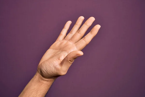 손바닥을 도움을 고립된 보라색 손가락을 내보이고 코카서스 젊은이의 — 스톡 사진