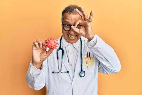 中世インドの男身に着けています医師のコート保持ウイルスおもちゃ笑顔幸せな行いますOk Signとともに手で目を通して指を見て — ストック写真