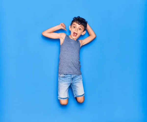 Adorable Niño Con Ropa Casual Saltando Sobre Fondo Azul Aislado — Foto de Stock