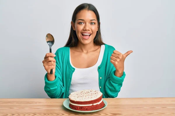 Schöne Hispanische Frau Isst Karottenkuchen Und Zeigt Den Daumen Zur — Stockfoto