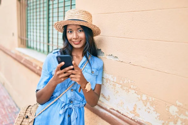 市内のスマートフォンを使って壁にもたれている若いインド人女性 — ストック写真