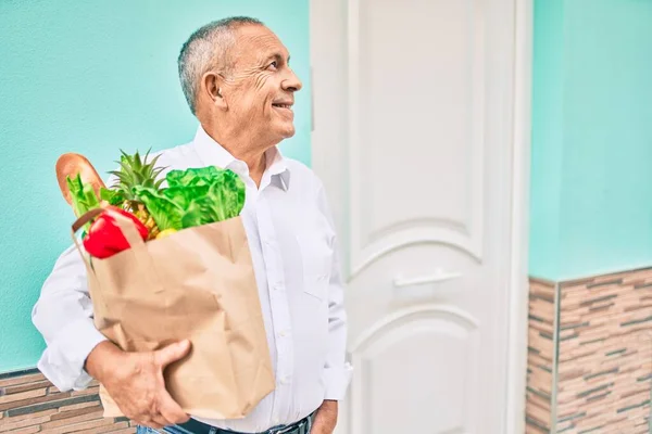 Hombre Mayor Sonriendo Feliz Sosteniendo Bolsa Papel Con Comida Caminando —  Fotos de Stock