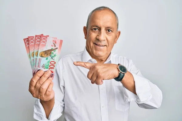 Handsome Senior Man Holding 100 New Zealand Dollars Banknote Smiling — Stock Photo, Image