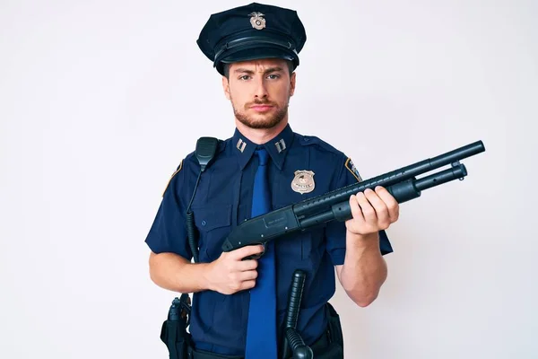 Young Caucasian Man Wearing Police Uniform Holding Shotgun Skeptic Nervous — Stock Photo, Image