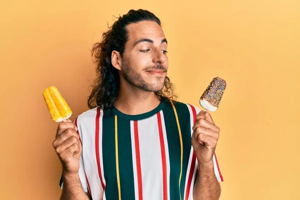 Joven Hombre Guapo Con Pelo Largo Comiendo Dos Helados Sonriendo —  Fotos de Stock