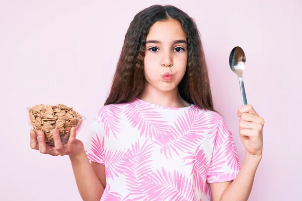 Cute Hispanic Girl Holding Cornflakes Spoon Puffing Cheeks Funny Face — 스톡 사진