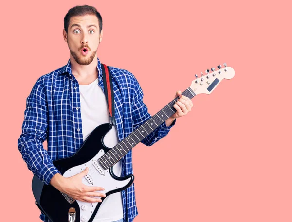 Young Handsome Caucasian Man Playing Electric Guitar Scared Amazed Open — Stock Photo, Image