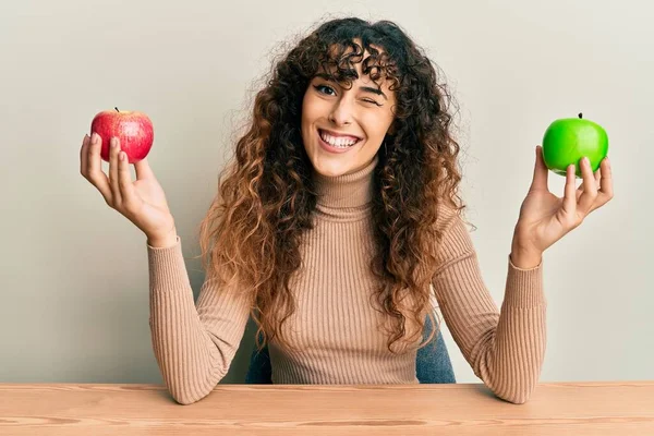 Junges Hispanisches Mädchen Mit Äpfeln Auf Dem Tisch Zwinkernd Die — Stockfoto