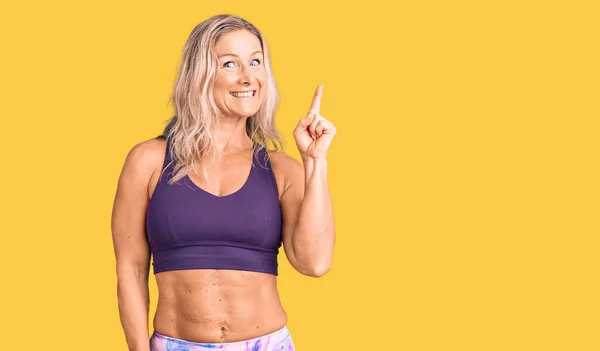 Middle Age Fit Blonde Woman Wearing Sportswear Pointing Finger Successful — Stock Photo, Image