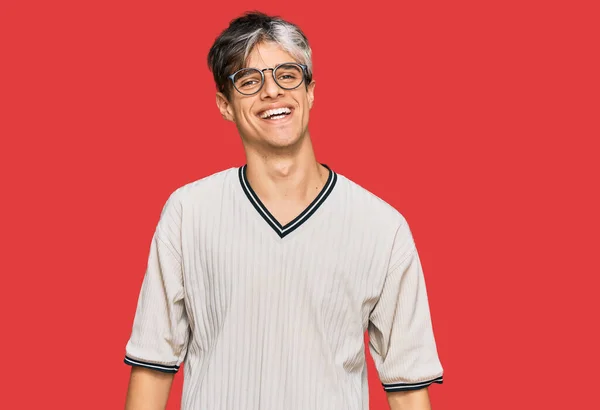 Молодой Латиноамериканец Повседневной Одежде Очках Выглядит Позитивно Счастливо Стоя Улыбаясь — стоковое фото