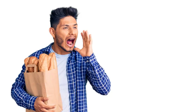 Yakışıklı Latin Amerikalı Genç Adam Elinde Ekmek Torbasıyla Bağırıyor Ağızdan — Stok fotoğraf