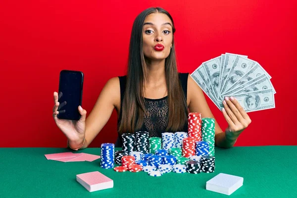 Νεαρή Ισπανίδα Που Παίζει Πόκερ Κρατώντας Smartphone Και Δολάρια Κοιτάζοντας — Φωτογραφία Αρχείου