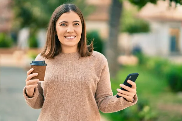 Jovem Hispânica Usando Smartphone Bebendo Café Parque — Fotografia de Stock