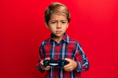Video oyunu oynayan sevimli Latin çocuk kontrolcü şüpheci ve gergin, sorun yüzünden surat asıyor. negatif kişi. 