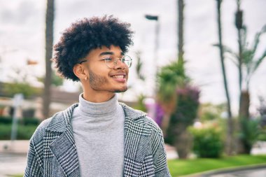 Genç Afrikalı Amerikalı iş adamı şehirde mutlu mesut dikiliyor..