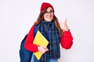 Kış eşarbı takan genç ve güzel bir kadın ve sırt çantası taşıyan mutlu ve pozitif gülümseyen bir öğrenci. 