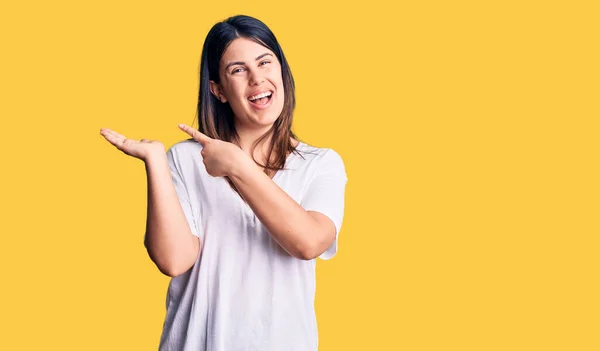 Jovem Bela Mulher Morena Vestindo Camiseta Casual Surpreendida Sorrindo Para — Fotografia de Stock