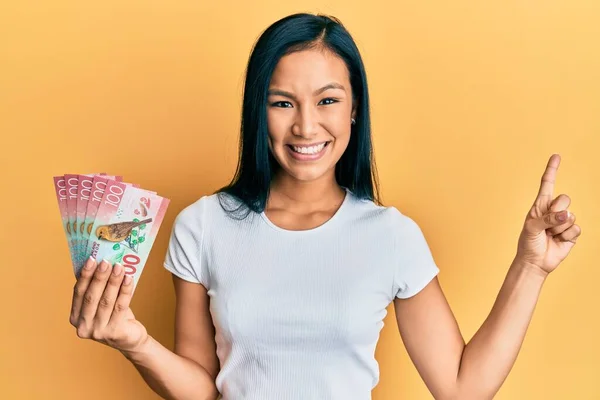 Krásná Hispánská Žena Drží 100 Novozélandských Dolarů Bankovky Úsměvem Šťastný — Stock fotografie